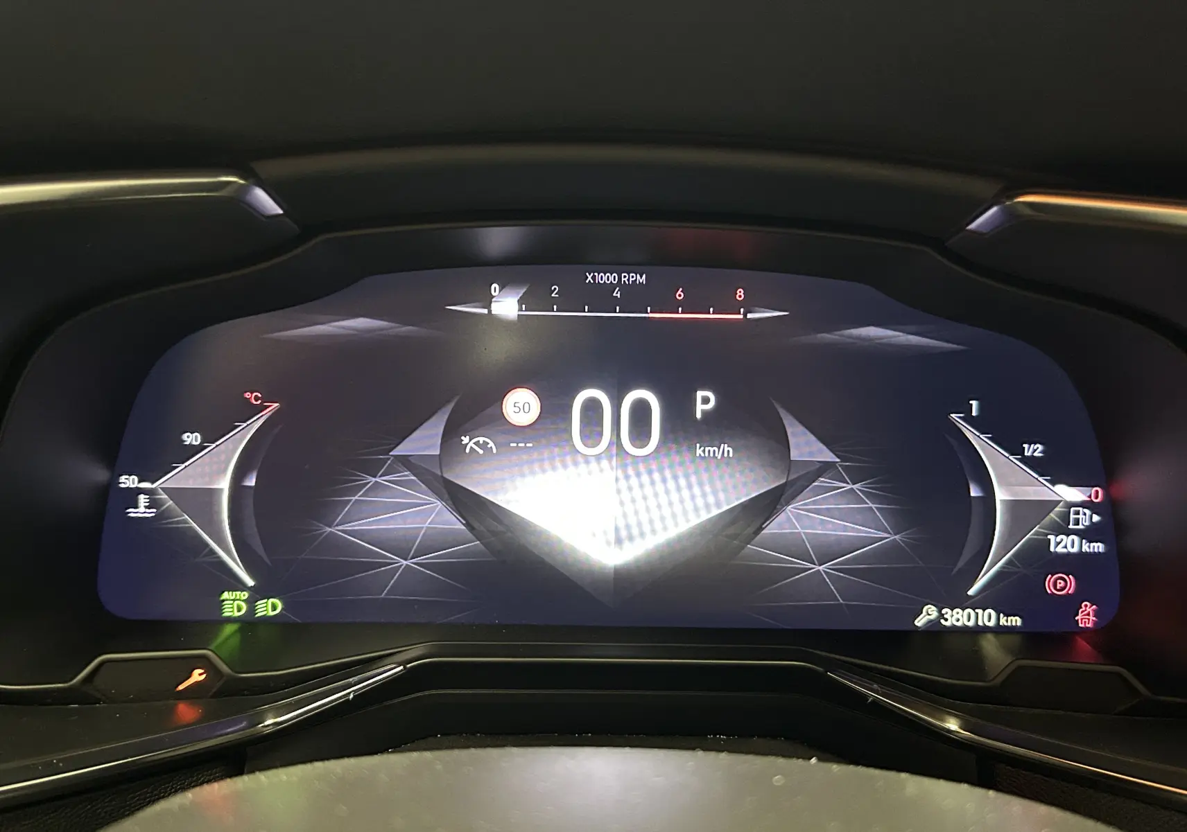 Vue rapprochée du tableau de bord numérique du DS7 2024 affichant la vitesse à 0 km/h et l'autonomie restante de 120 km.
