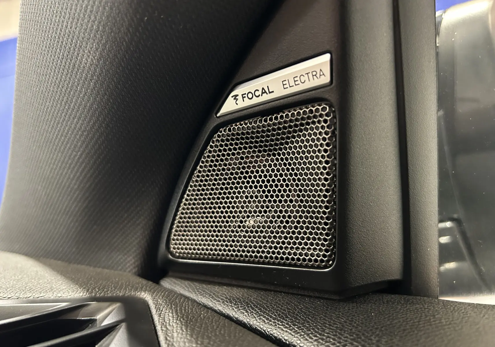 Gros plan sur l'enceinte Focal Electra intégrée à l'angle intérieur côté gauche du tableau de bord du DS7 gris titane.