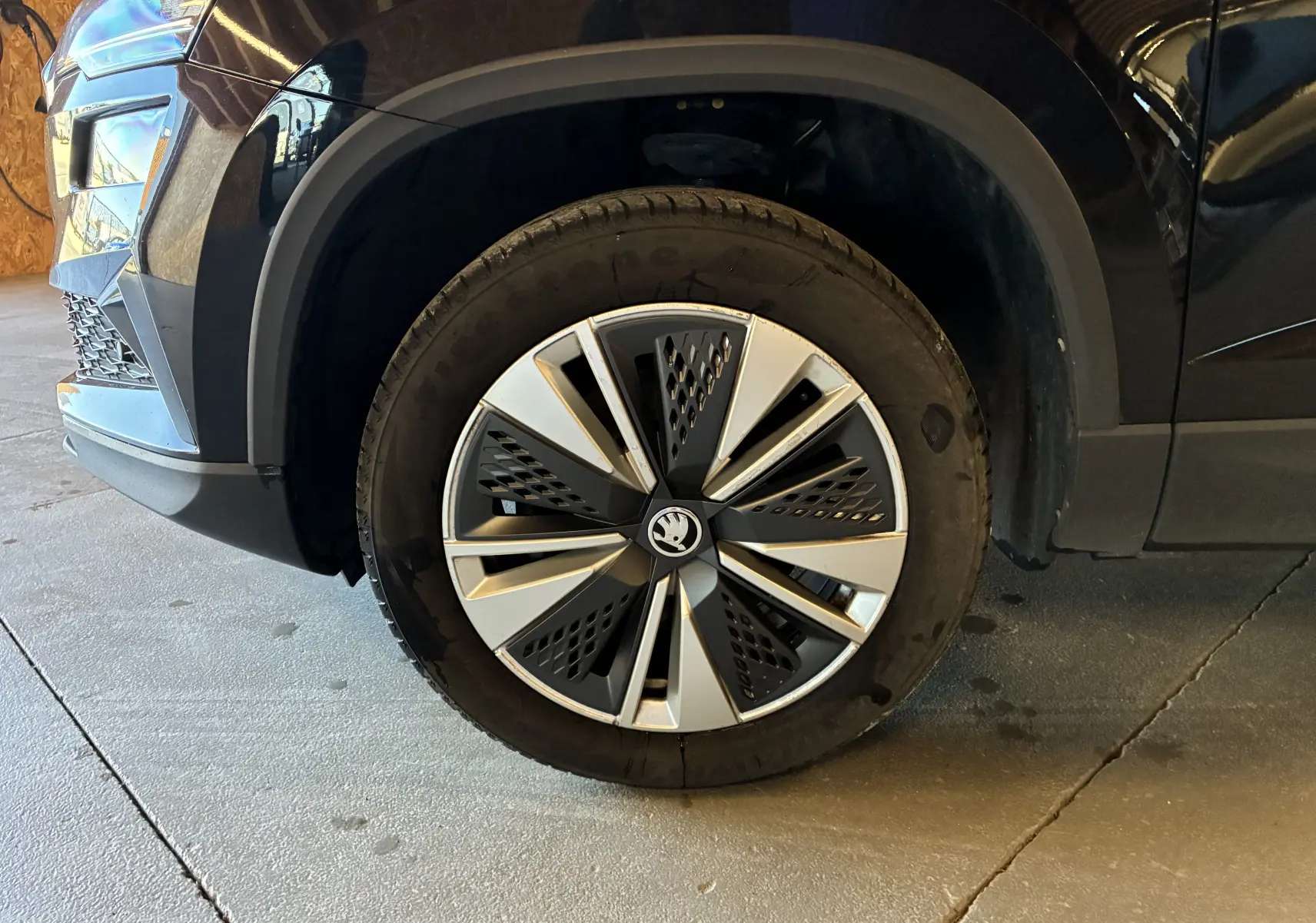 Gros plan sur la roue avant gauche noire du Skoda Karoq 2024 avec jante alliage 17'' SCUTUS et enjoliveur noir mat.