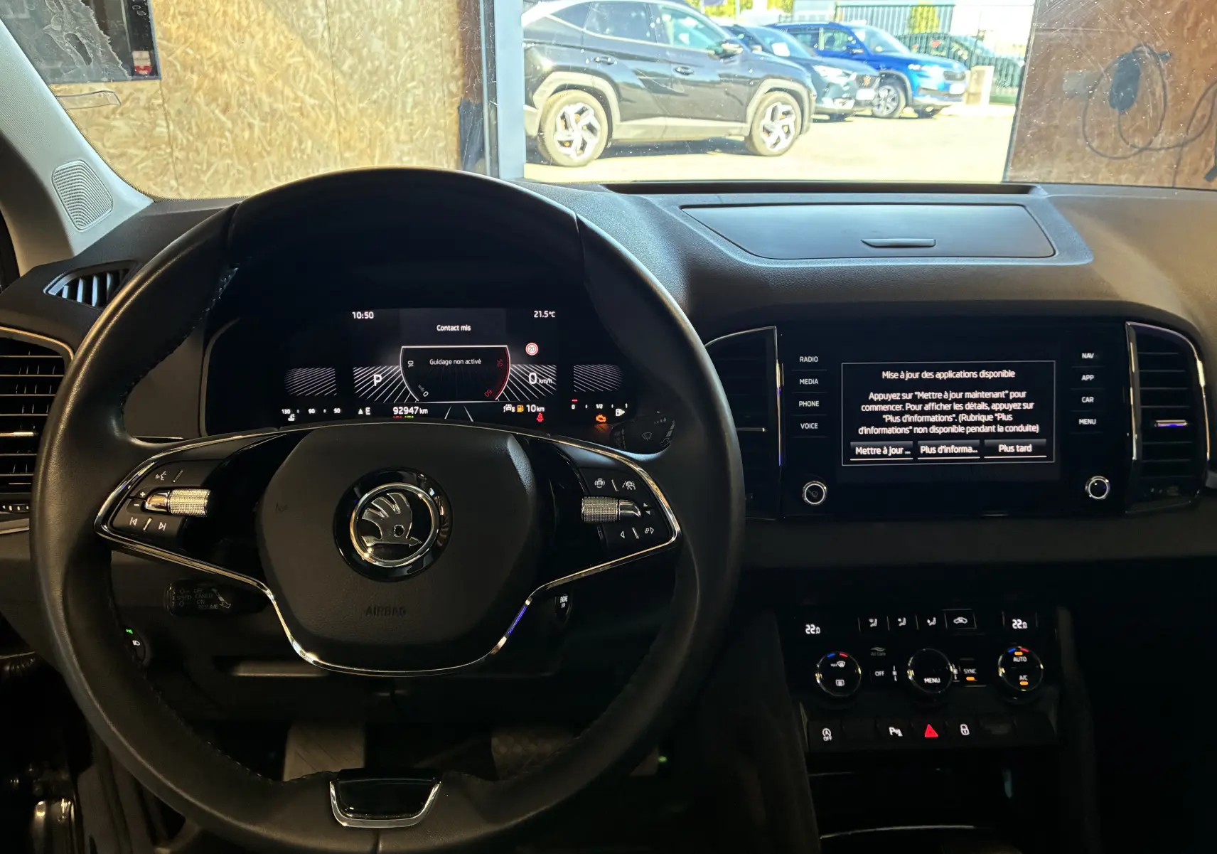 Vue intérieure centrée sur le volant multifonctions et le tableau de bord numérique du Skoda Karoq noir 2024.