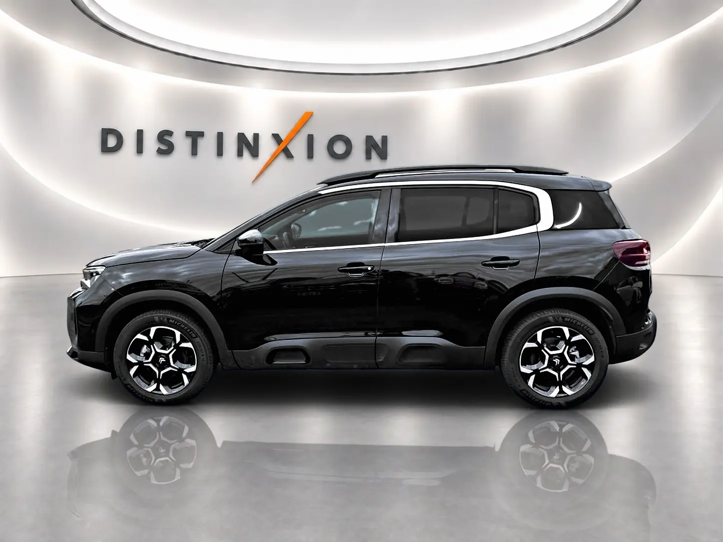 Profil droit du SUV Citroën C5 Aircross noir 2025 avec jantes alliage et barres de toit visibles en showroom.