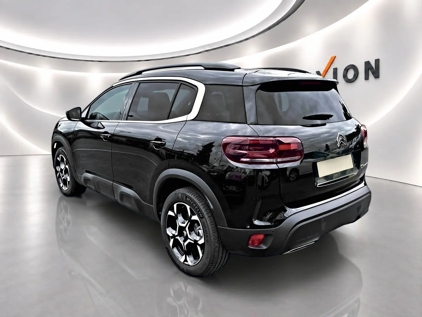 Citroën C5 Aircross noir vue 3/4 arrière droit, jantes alu et vitres arrière teintées dans un showroom lumineux.