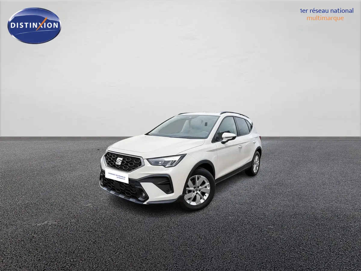 SEAT Arona blanc vue 3/4 avant droit sur sol gris, avec calandre noire et jantes alliage 16 pouces design.