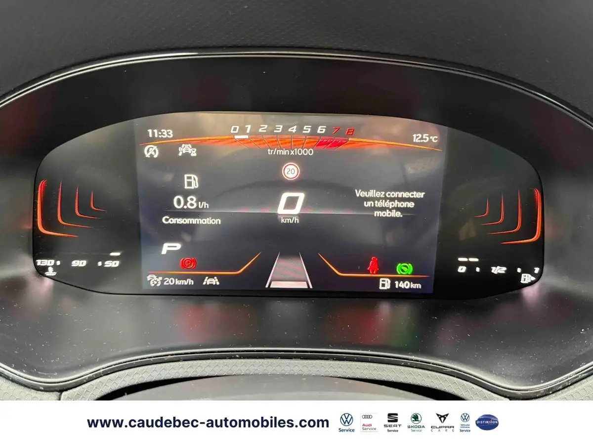 Affichage numérique du tableau de bord du SEAT Arona blanc, montrant la consommation et la vitesse à 0 km/h.