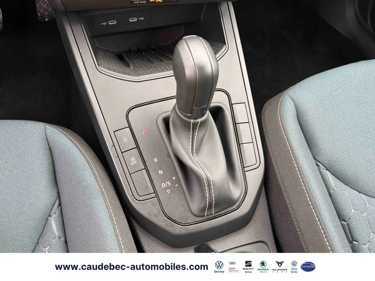 Gros plan sur la console centrale du SEAT Arona 2026, montrant le levier de vitesses DSG noir et les sièges tissu gris.