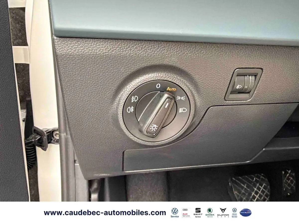Détail du panneau de commande des phares sur la gauche du tableau de bord d’un SEAT Arona blanc.