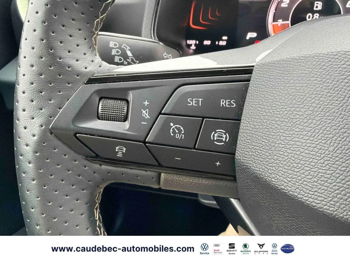 Gros plan sur les commandes du volant en cuir perforé du SEAT Arona, avec boutons de régulateur adaptatif et assistance au maintien de voie.