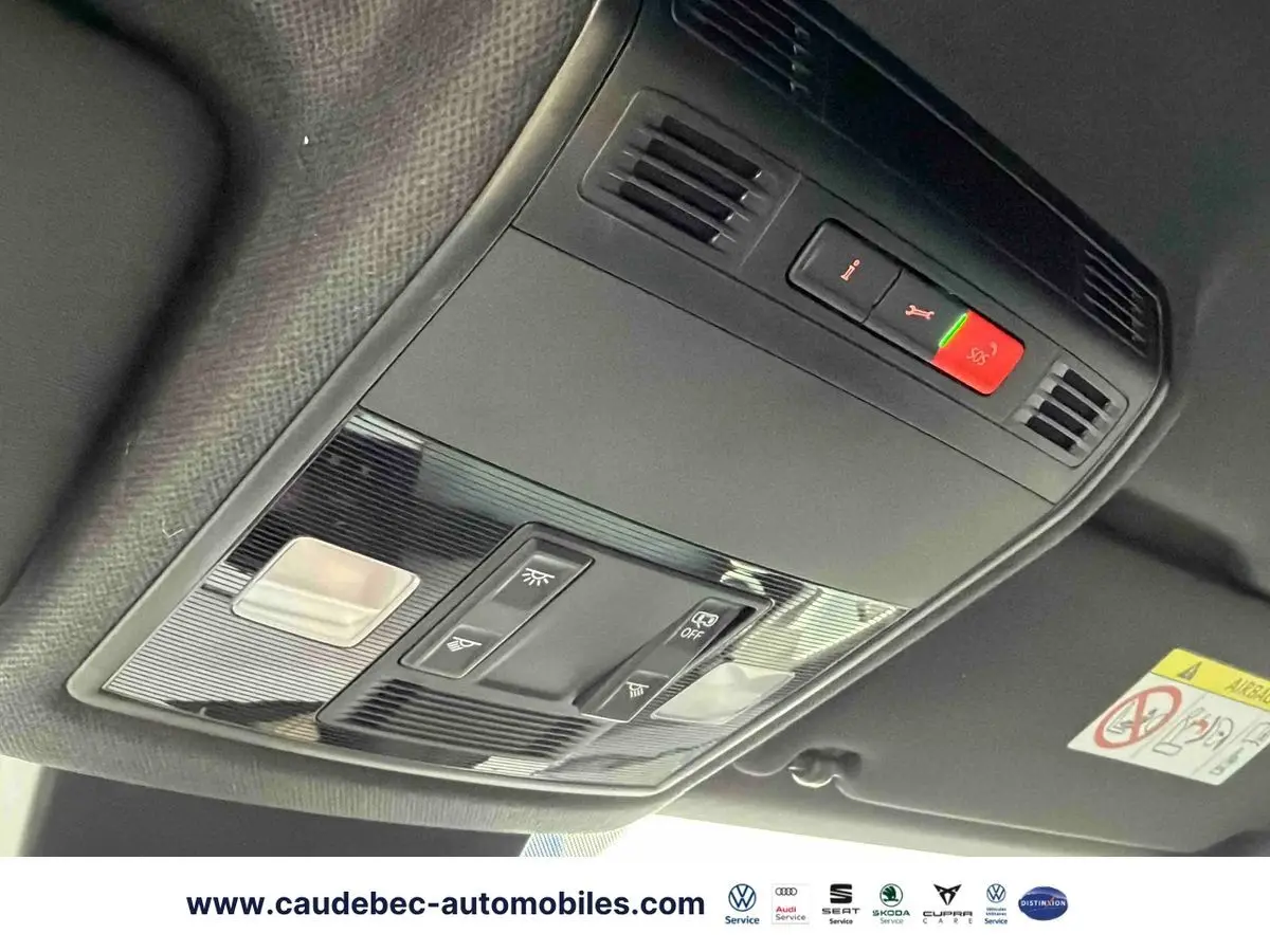 Vue en contre-plongée du plafonnier intérieur noir avec commandes d’éclairage et bouton SOS du SEAT Arona blanc.