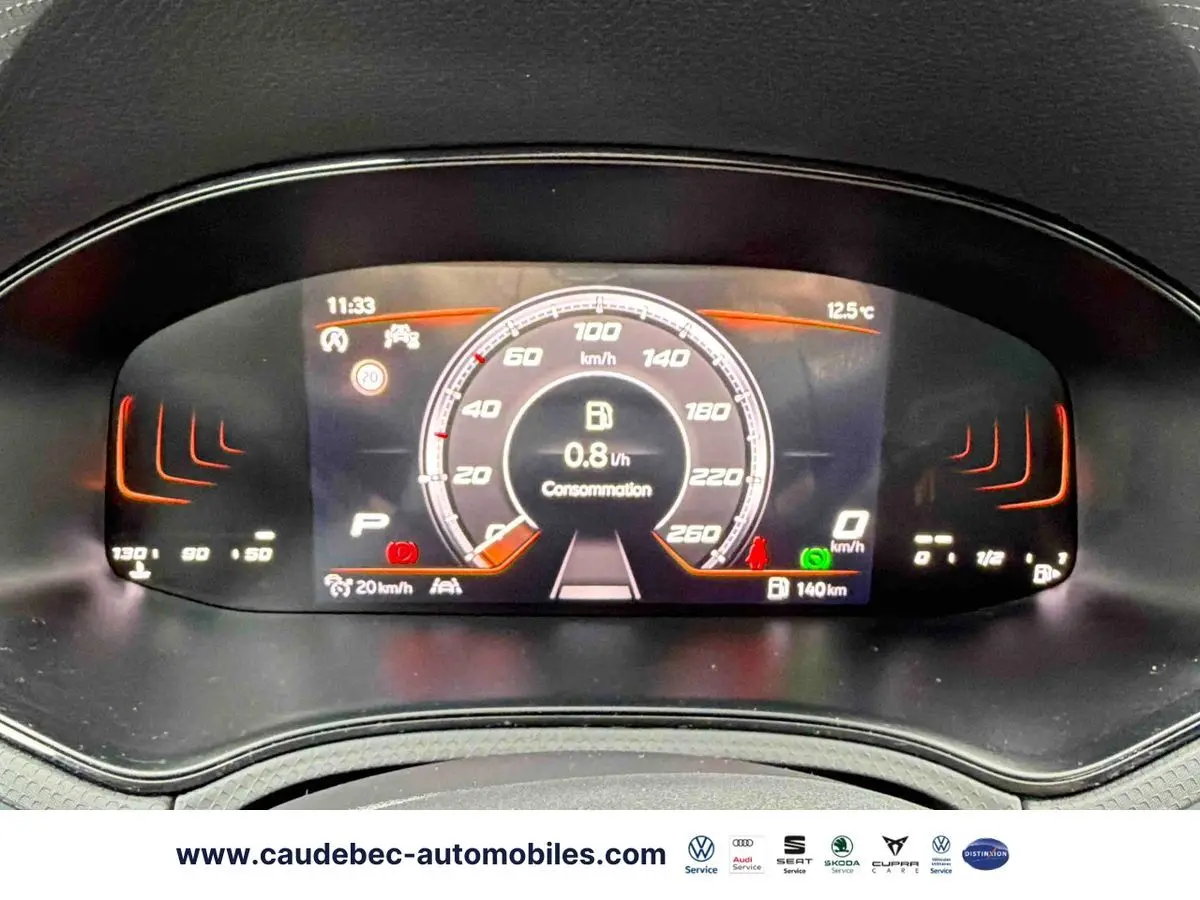 Tableau de bord numérique du SEAT Arona blanc, affichant la vitesse, consommation et alertes à 11h33.