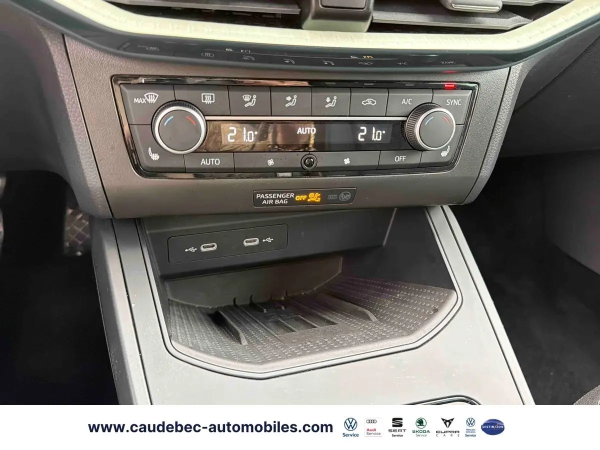 Vue rapprochée de la console centrale avec commandes de climatisation automatique et ports USB du SEAT Arona blanc.