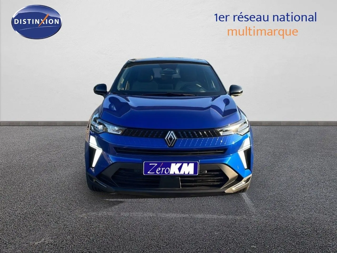 Vue frontale d'un Renault Captur E-Tech hybride bleu Iron Metal avec toit noir, éclairage LED allumé.