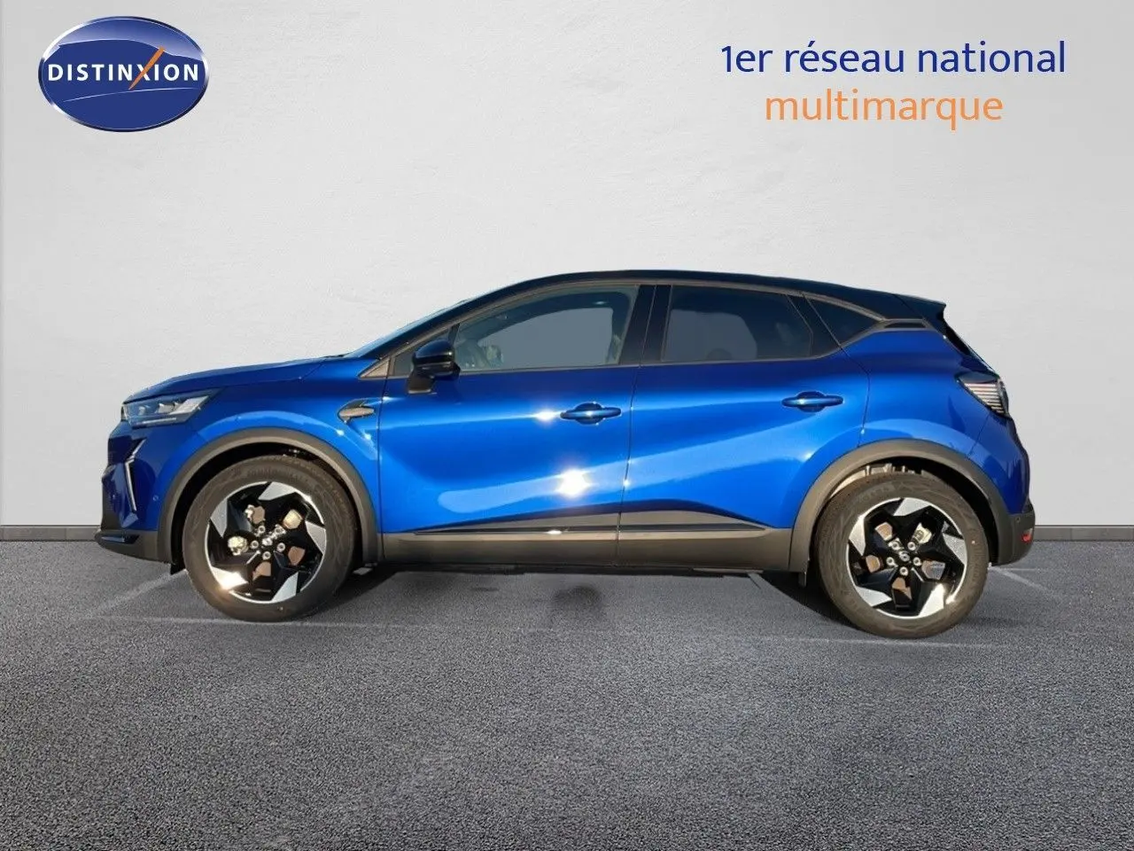 Profil côté gauche du Renault Captur E-Tech hybride 2025 en bleu Iron Metal avec toit noir et jantes biton.
