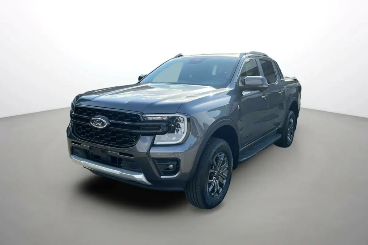 Ford Ranger 2025 gris carbone en 3/4 avant droit avec calandre noire et barres de toit visibles