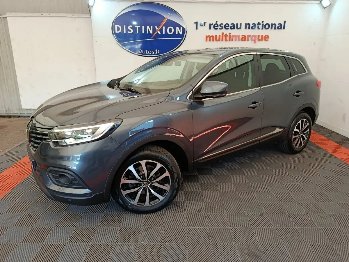 Renault Kadjar Business gris foncé vu en 3/4 avant droit, avec jantes alliage et feux LED dans un showroom.