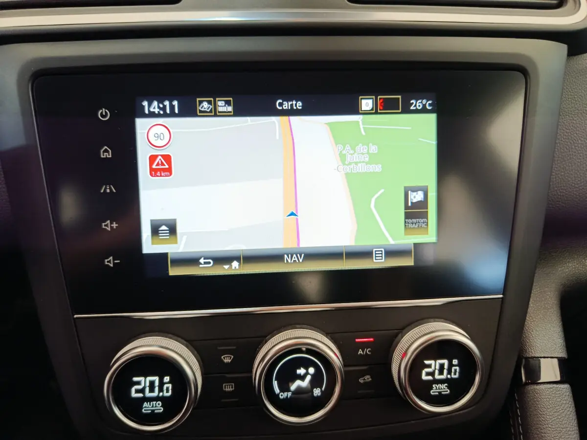 Écran tactile central affichant la navigation et commandes climatisation digitale du Renault Kadjar gris foncé, vue intérieure frontale.