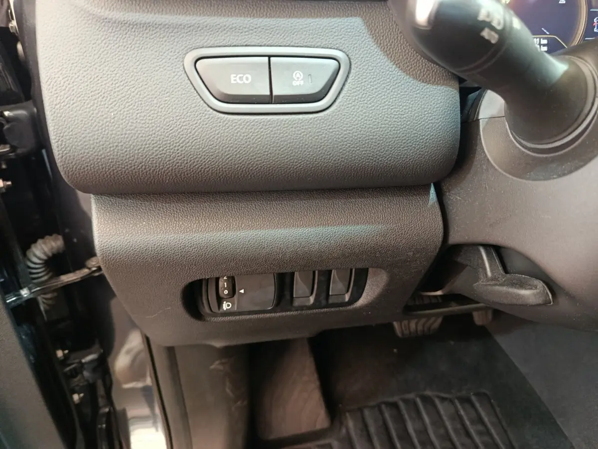 Vue intérieure côté gauche du tableau de bord du Renault Kadjar 2022, boutons Eco et réglage phares visibles.