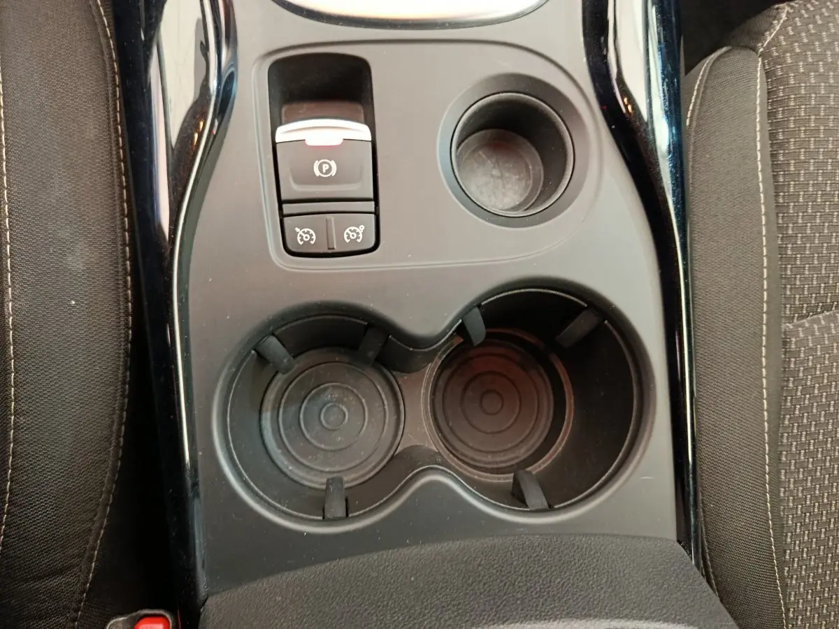 Vue plongeante sur la console centrale noire du Renault Kadjar Business Blue dCi 115 EDC 2022 avec frein à main électrique et porte-gobelets.