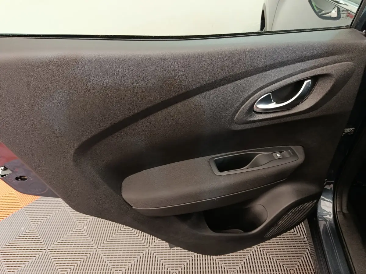 Porte intérieure côté droit du Renault Kadjar Business gris foncé, avec poignée argentée et commande de vitre.