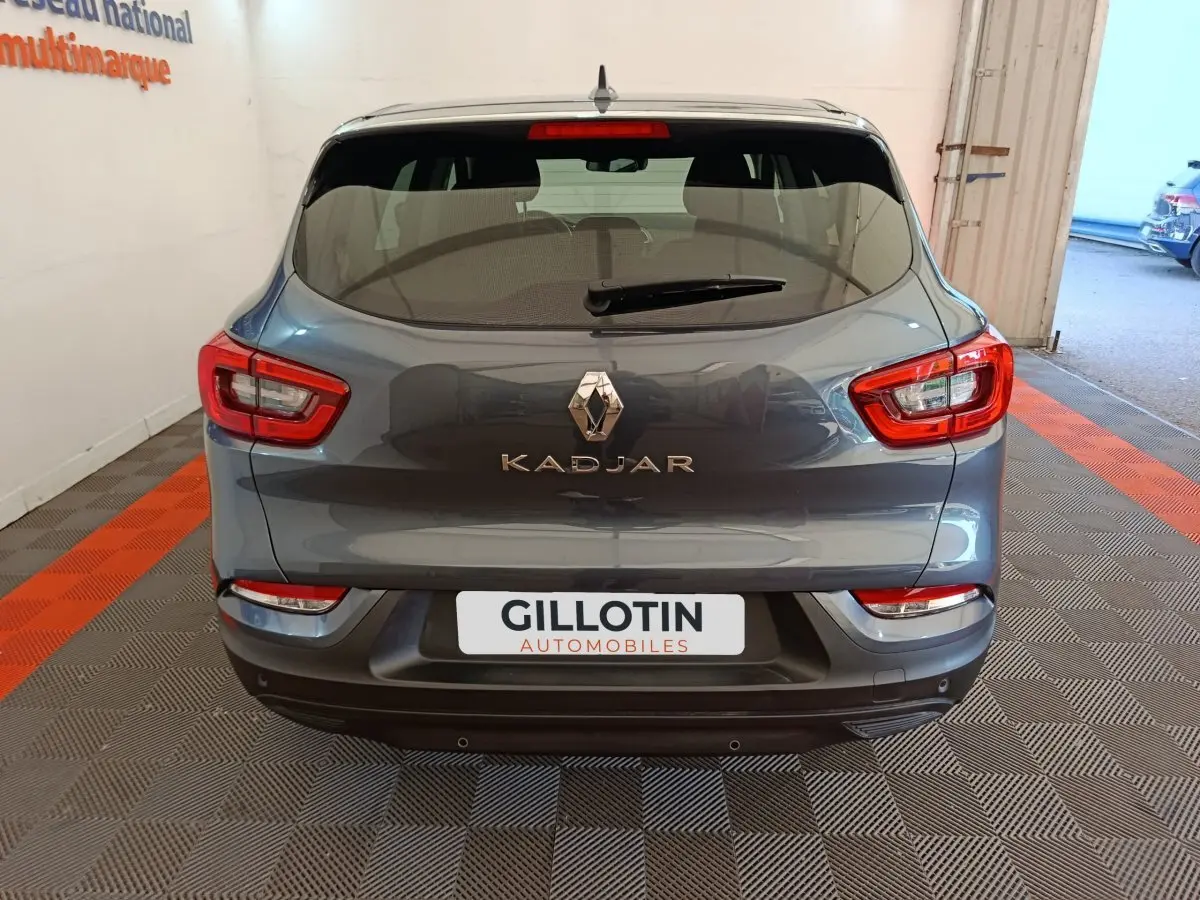 Vue arrière d'un Renault Kadjar gris foncé 2022 avec feux rouges et logo chromé bien visibles.