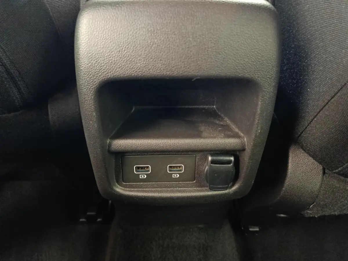 Prise USB double et prise 12V noire sous l'accoudoir arrière du Renault Kadjar Business gris foncé 2022.