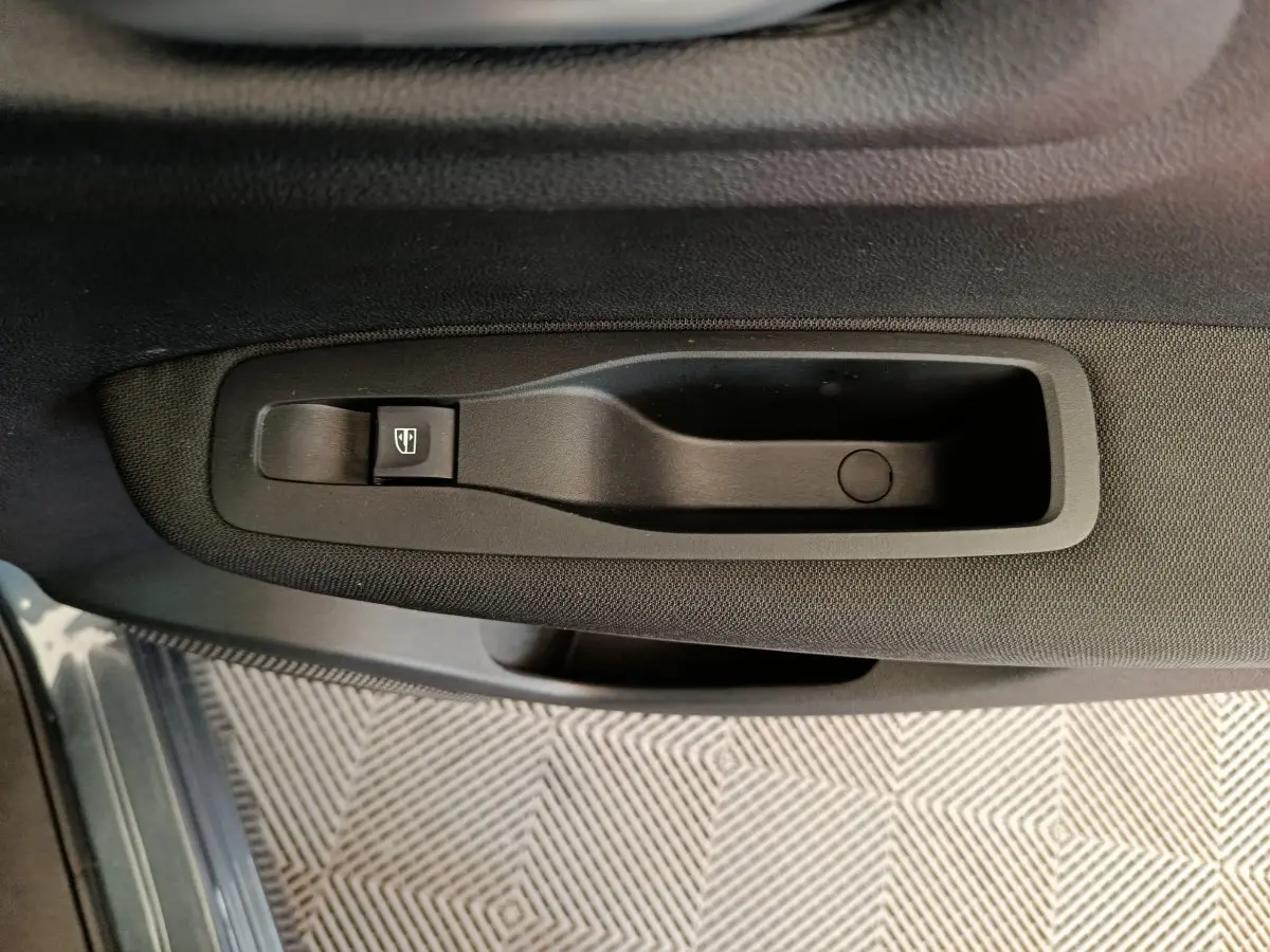 Poignée intérieure de porte côté gauche avec commande de lève-vitre sur Renault Kadjar gris foncé Business 2022.