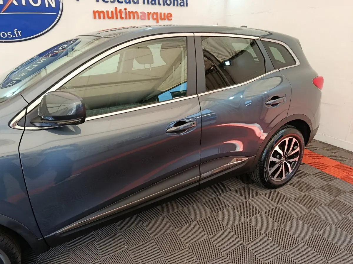 Profil côté gauche du Renault Kadjar gris foncé 2022 avec jantes alliage et rétroviseurs électriques chromés.