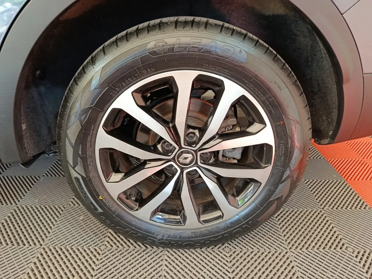 Gros plan sur la roue avant droite du Renault Kadjar gris foncé avec jante alliage à motifs noirs et argentés.