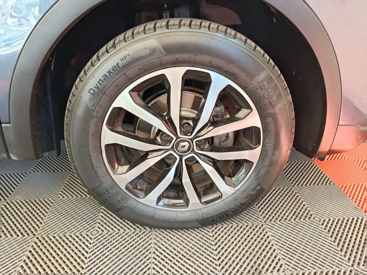 Gros plan sur la roue avant droite du Renault Kadjar gris foncé, mettant en valeur la jante alliage et le pneu Dynaxer HP5.