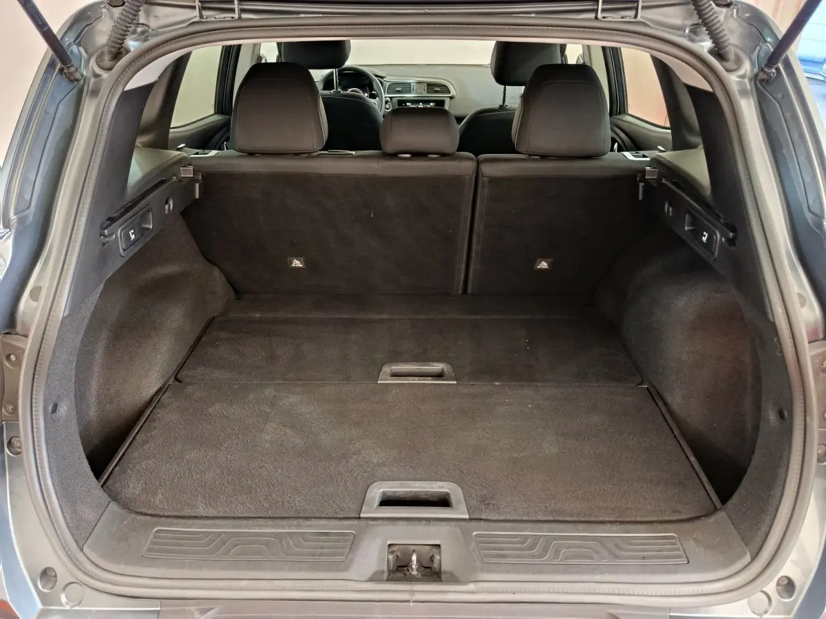 Vue depuis l'arrière du coffre spacieux du Renault Kadjar Business gris foncé avec banquette rabattue et intérieur noir.
