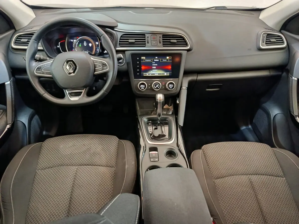Vue intérieure avant du Renault Kadjar Business 2022 montrant le volant multifonctions, écran tactile central et sièges noirs.