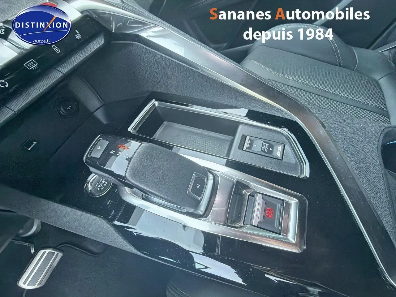 Gros plan sur la console centrale noire brillante du Peugeot 3008 GT Pack Black avec levier de vitesse automatique.