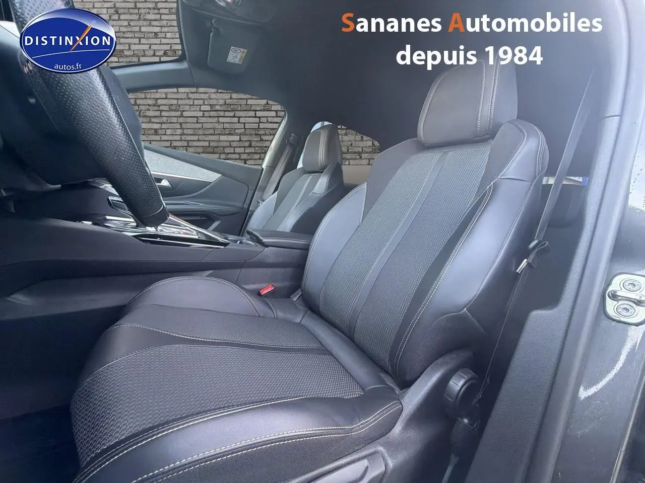 Vue intérieure côté conducteur du Peugeot 3008 gris foncé, mettant en valeur les sièges en cuir noir avec surpiqûres contrastées.