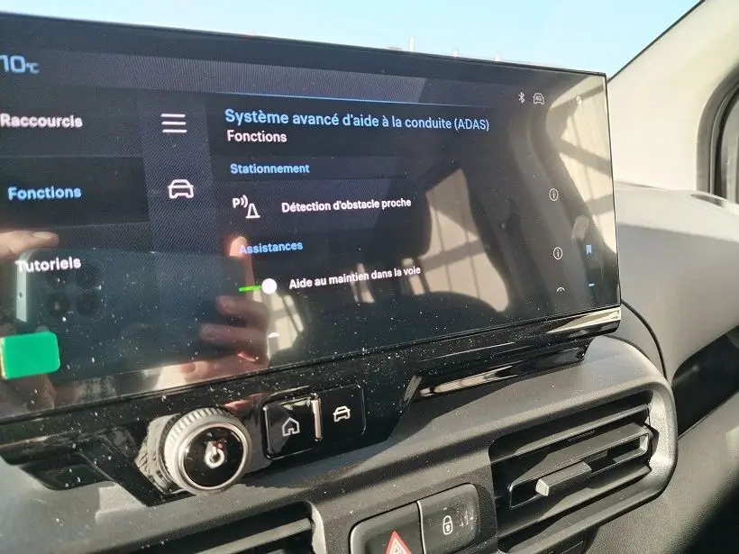 Écran tactile du système d’aide à la conduite sur tableau de bord intérieur du Peugeot Rifter vert Srikka, vue de côté droit.