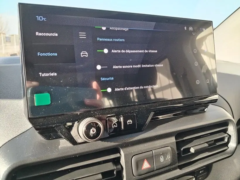 Écran tactile central du Peugeot Rifter 2025 affichant les alertes de sécurité, avec commandes et aérateurs en dessous.