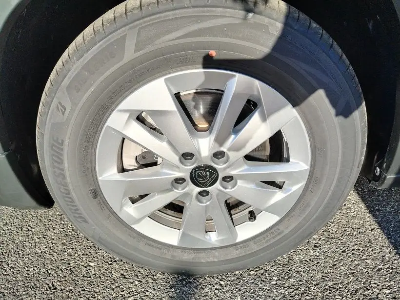 Gros plan sur la roue avant droite du Peugeot Rifter 2025 en Srikka Green, avec jante alliage argentée et logo Peugeot.