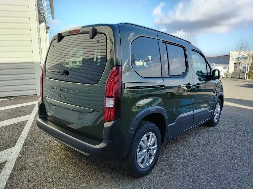 Vue 3/4 arrière droit d'un Peugeot Rifter 2025 vert Srikka avec hayon et vitres teintées.