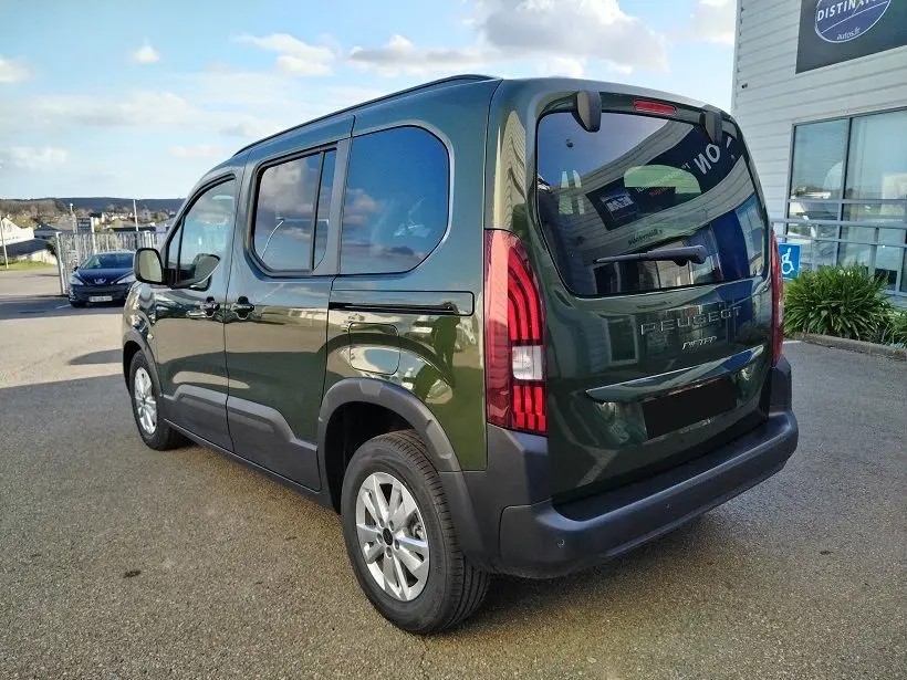 Vue 3/4 arrière droite d'un Peugeot Rifter 2025 vert Srikka avec feux arrière LED et hayon vitré.