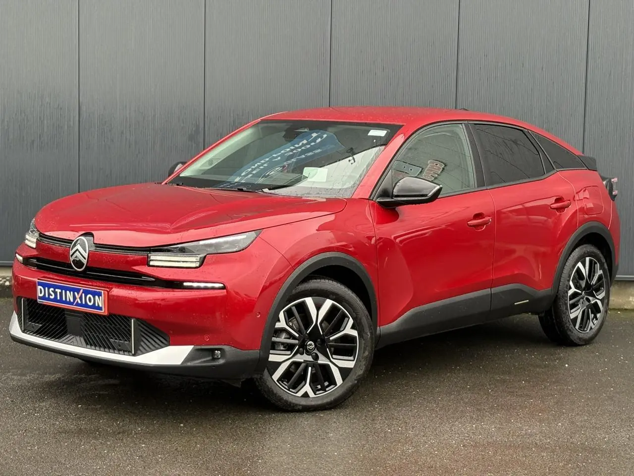 Citroën C4 Hybrid 2025 rouge Elixir en 3/4 avant droit, avec jantes alliage diamantées et détails noirs contrastants.