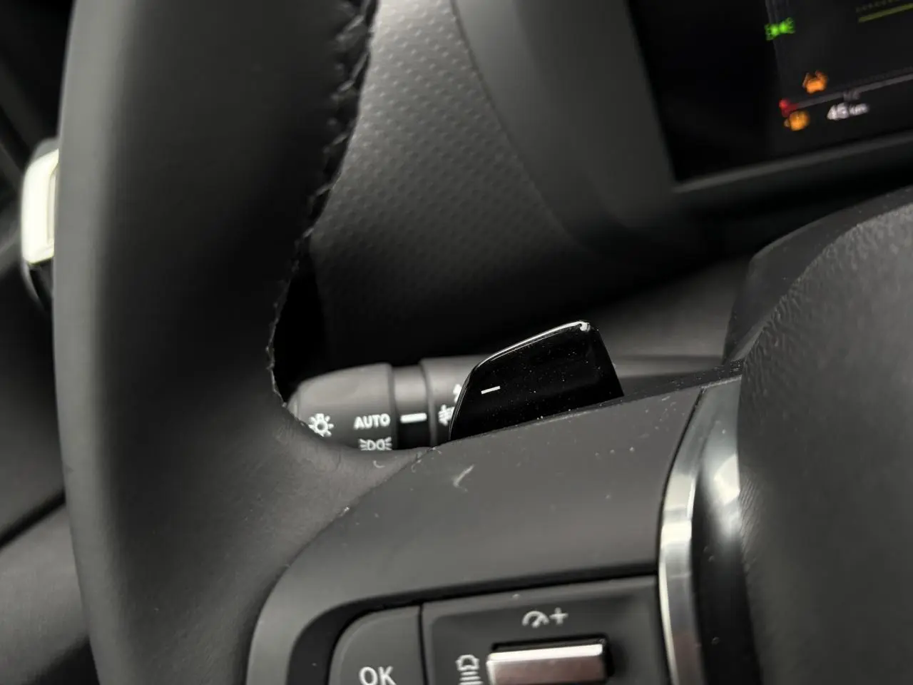 Gros plan sur la palette de changement de rapports côté droit du volant cuir de la Citroën C4 Hybrid 145 rouge Elixir.