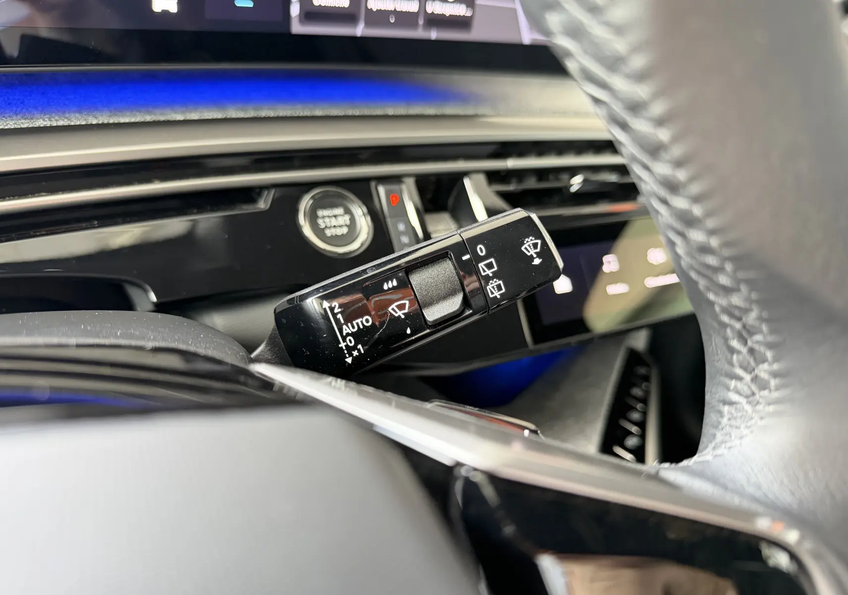 Gros plan sur la commande d’essuie-glace à gauche du volant dans l’habitacle gris du Peugeot 1007 Hybrid 2026.