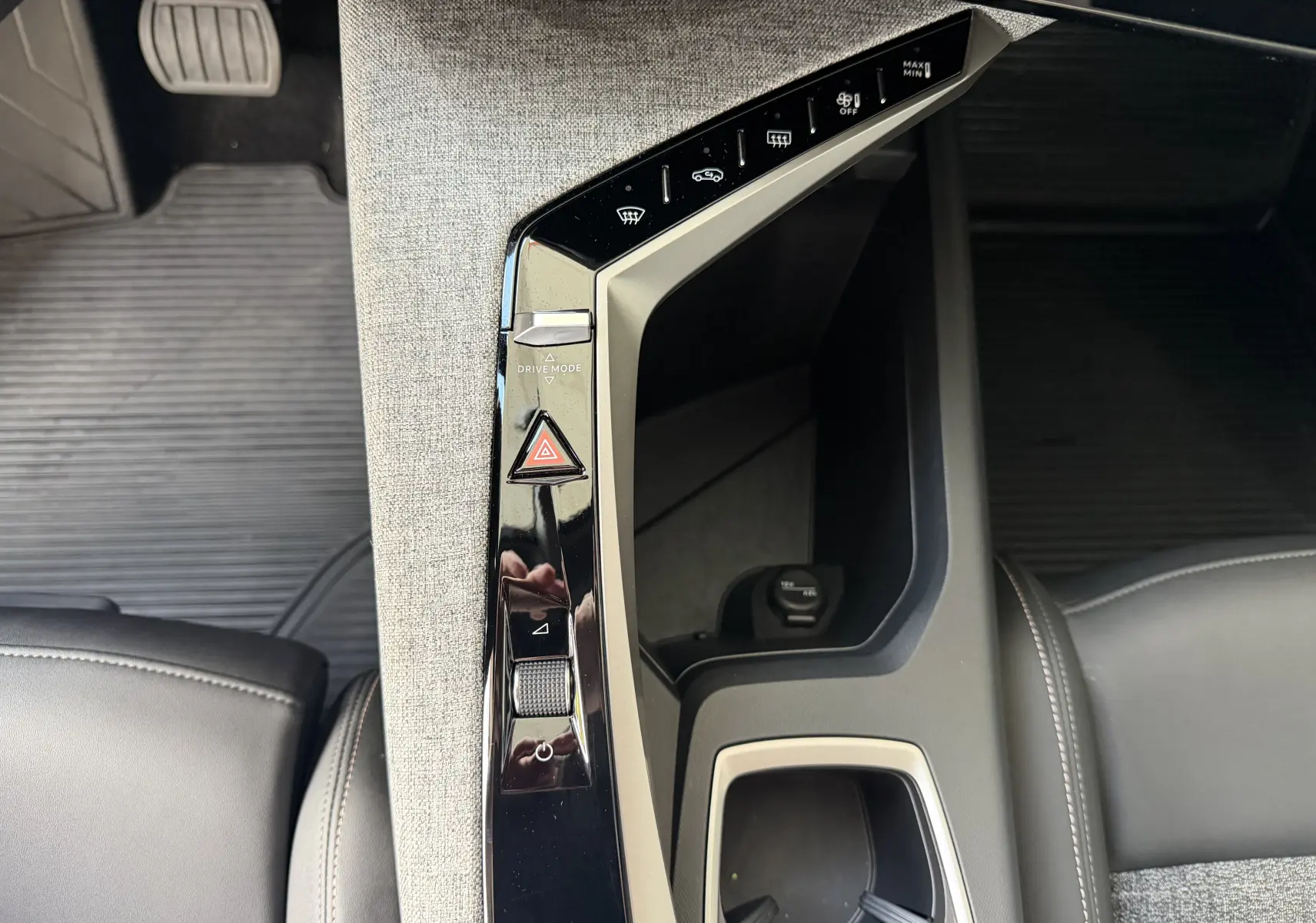 Vue plongeante sur la console centrale intérieure du Peugeot 1007 gris artense, avec commandes tactiles et tissu clair.