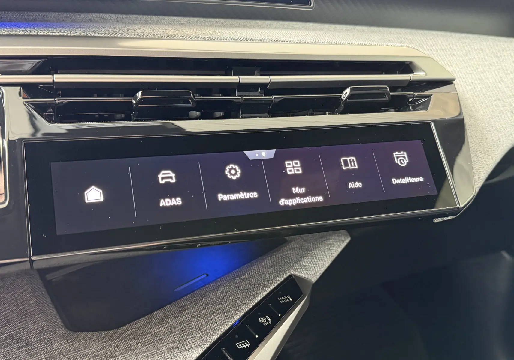 Vue rapprochée de l’écran tactile central et des aérateurs du tableau de bord gris clair du Peugeot 1007 Hybrid 145 2026.