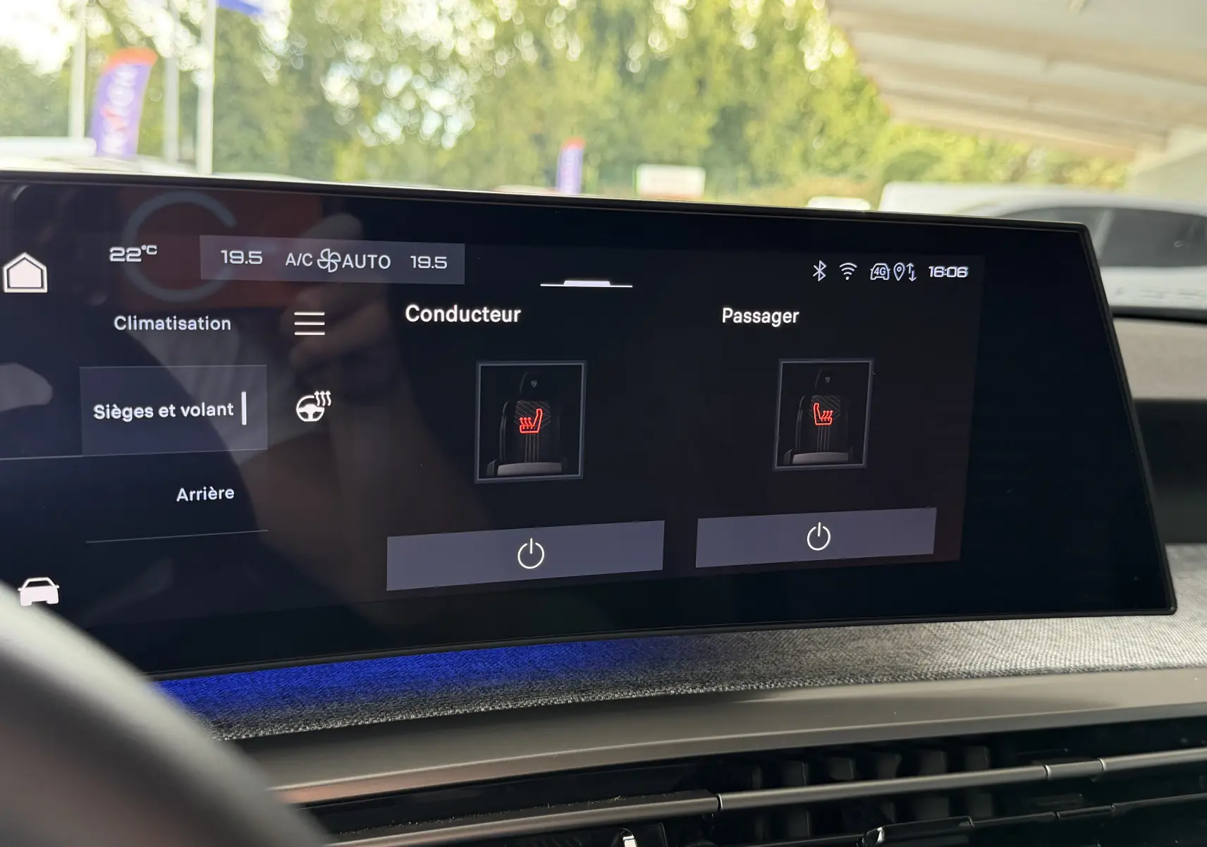 Écran tactile intérieur de la Peugeot 1007 gris artense montrant les réglages de sièges chauffants conducteur et passager.