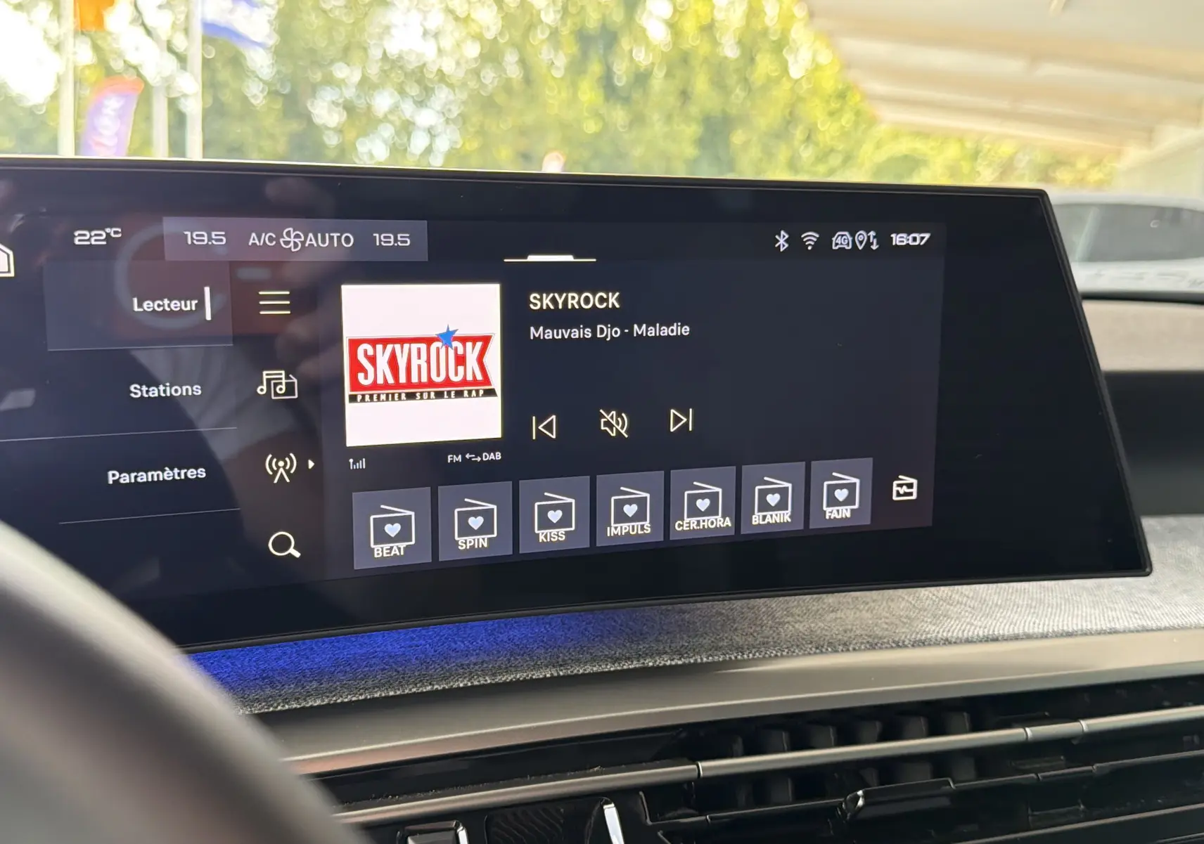 Écran tactile central affichant la radio Skyrock dans l’habitacle gris artense du Peugeot 1007 hybride, vue de face.