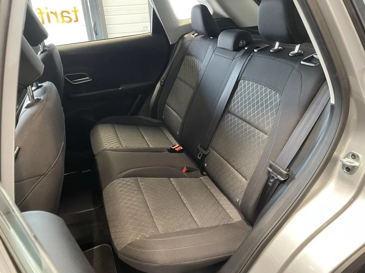 Vue intérieure côté droit sur la banquette arrière en tissu noir du MG Motor ZS 1.5 Hybrid+ gris clair 2026.