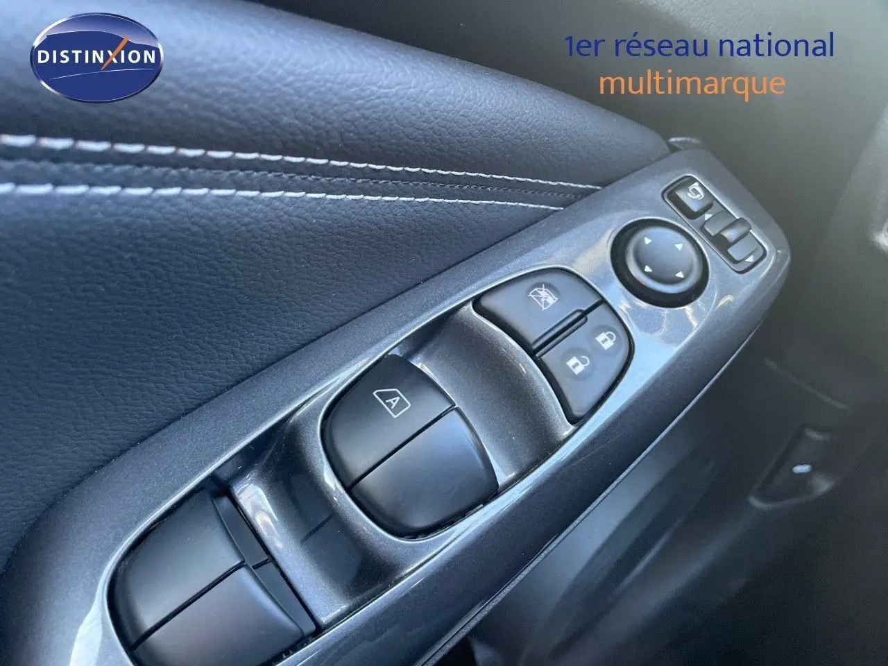 Gros plan sur les commandes de lève-vitres et rétroviseurs côté conducteur du Nissan Juke gris squale métal 2024.