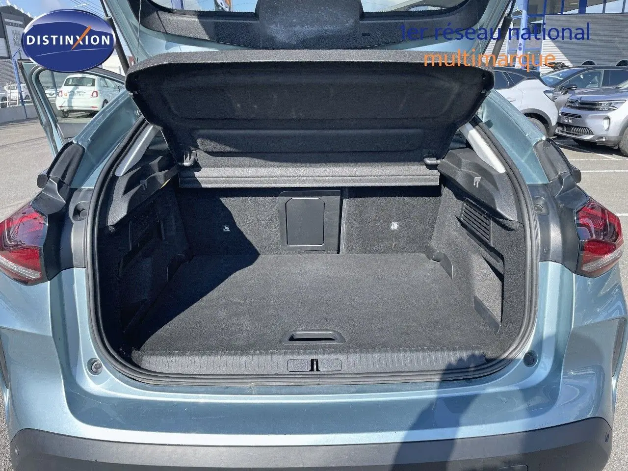 Coffre ouvert vu de l'arrière d'une Citroën C4 bleu Iceland Metal, montrant l'espace de chargement vide.