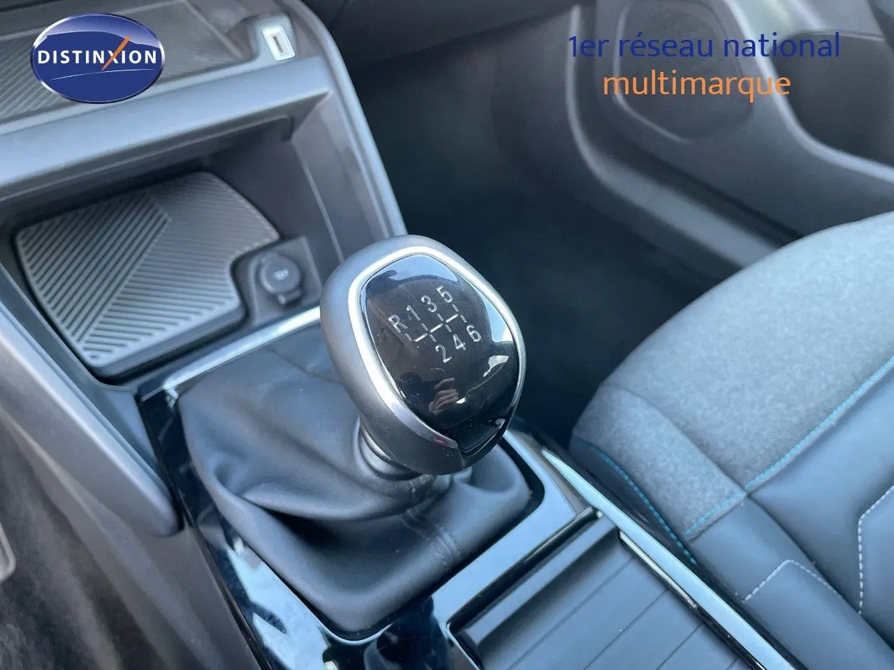 Gros plan sur le levier de vitesse manuel de la Citroën C4 2021, avec siège tissu gris et coutures bleues en arrière-plan.