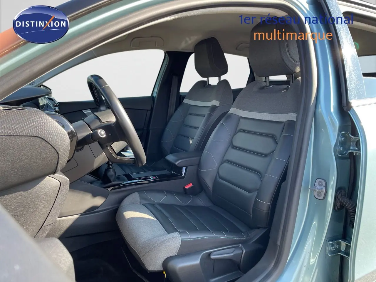 Vue intérieure côté conducteur de la Citroën C4 2021 bleu Iceland Metal avec sièges bi-matière gris et noir.