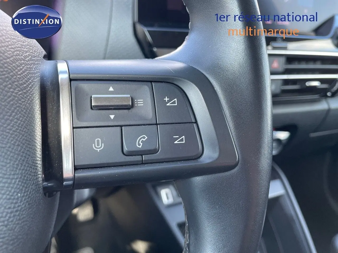 Gros plan sur les commandes au volant à gauche d'une Citroën C4 2021, intérieur noir avec boutons de volume et appel.